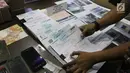 Petugas menata barang bukti TPPU narkotika di kantor BNN, Jakarta, Selasa (26/1). Dalam kasus ini Petugas juga menyita 3 unit apartemen, 6 unit ruko, 1 unit rumah, 3 unit mobil, 2 unit toko dan uang senilai Rp 1,6 miliar. (Liputan6.com/Arya Manggala)