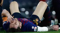 Megabintang Barcelona, Lionel Messi meringis kesakitan setelah mendarat tak sempurna saat terjatuh dalam lanjutan Liga Spanyol di Camp Nou, Minggu (21/10). Messi mengalami cedera patah tulang tangan saat berduel dengan pemain Sevilla. (AP/Manu Fernandez)