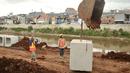 Pekerja memasang beton saluran air di proyek normalisasi Ciliwung, Bukit Duri, Jakarta, Rabu (8/2). Penyelesaian normalisasi Ciliwung mencakup pembangunan dinding parapet, sheetpile, jalan inspeksi maupun saluran air.(Liputan6.com/Yoppy Renato)
