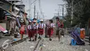 Sejumlah siswa siswi SD melintas di rel kereta di kawasan Kampung bandan, Jakarta, Selasa (28/7/2015).  Pemprov DKI Jakarta berencana menata sekitar Stasiun dengan membangun rumah susun yang memanfaatkan lahan milik PT KAI. (Liputan6.com/Faizal Fanani)