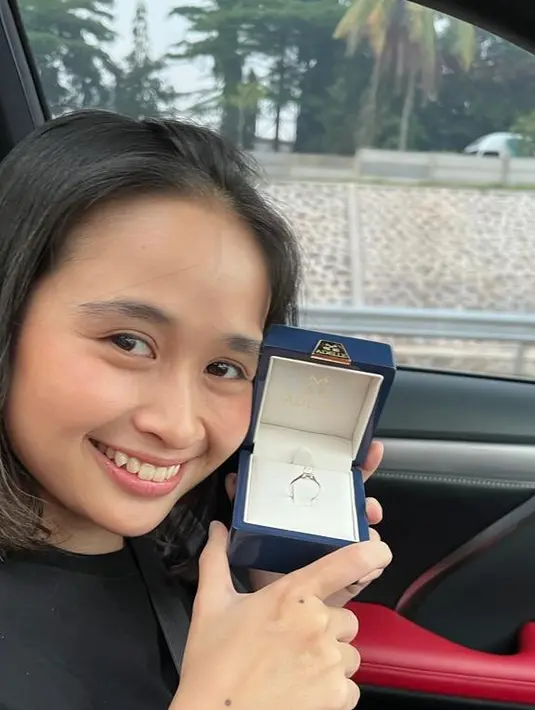 Dalam video yang dibagikan, Gritte tampak serius memeng handphone. Sedangkan Arif Hidayat yang mengemudi mobil memanggilnya dan menyodorkan kotak biru berisi cincin. Potret bahagia pemeran yang juga produser itu memperlihatkan cincin dari sang kekasih. [Instagram/gritteagathaa]