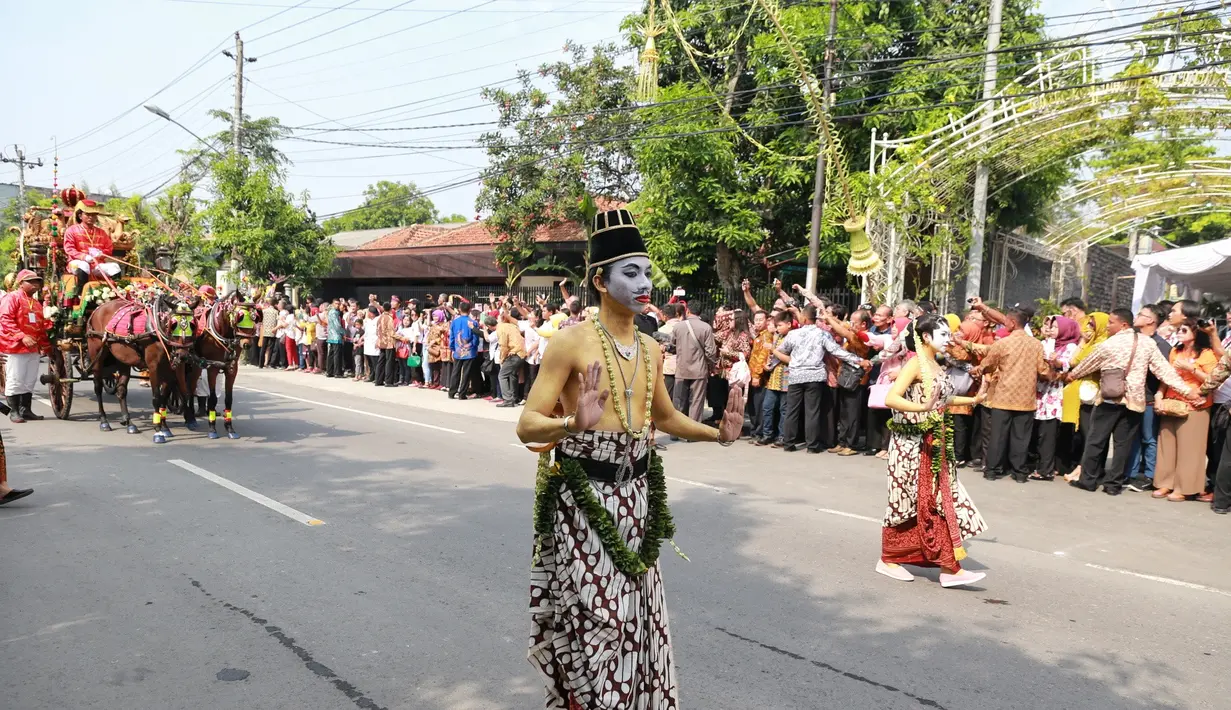 Menanti rombongan presiden yang lewat dengan kereta kencananya, masyarakat rela berdiri di sepanjang jalan dari kediaman Jokowi ke gedung pernikahan yang berjarak hanya sekitar 300m. (Adrian Putra/Bintang.com)