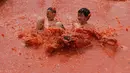 Dua anak laki-laki melompat ke dalam kolam berisi tomat selama Festival Tomat di Hwacheon, Korea Selatan, 5 Agustus 2017. Festival untuk merayakan panen tomat ini berlangsung dari 4 - 7 Agustus. (AP Photo/Ahn Young-joon)