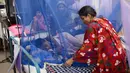 Seorang wanita merapikan tempat tidur anaknya yang menjadi pasien demam berdarah di Rumah Sakit Shishu Dhaka, Bangladesh, Rabu (31/7/2019). Banyak rumah sakit dibanjiri pasien penyakit itu sehingga semakin membebani sistem layanan medis yang saat ini sudah kewalahan. (AP Photo/Mahmud Hossain Opu)