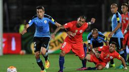 Pemain Cile, Arturo Vidal dan Alexis Sanchez, berebut bola dengan pemain Uruguay pada laga Kualifikasi Piala Dunia 2018 zona CONMEBOL di Stadion Nasional Julio Martinez Pradanos, Santiago, Rabu (16/11/2016) pagi WIB. (AFP/Martin Bernetti)