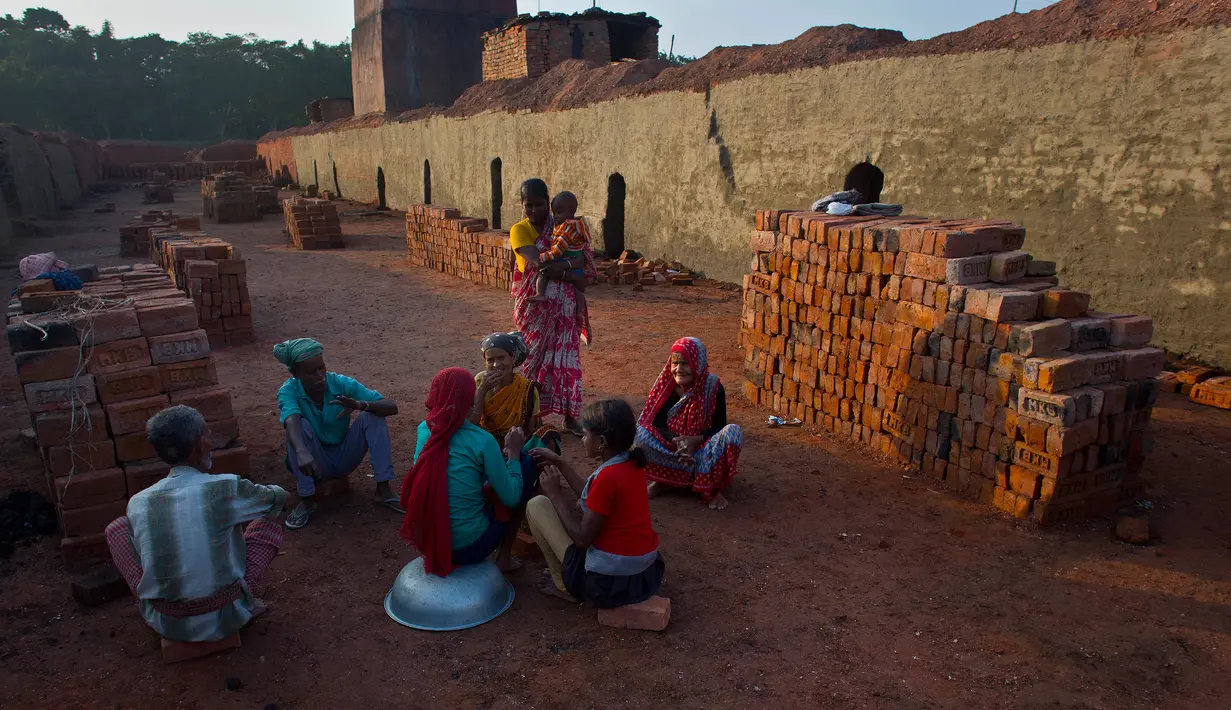 Para pekerja India beristirahat ketika mereka bekerja di sebuah pabrik batu bata di pinggiran Gauhati, India (22/11). Sebagian besar buruh di sini mendapatkan Rupee 120 (kurang dari 2 Dolar) per hari. (AP Photo/Anupam Nath)