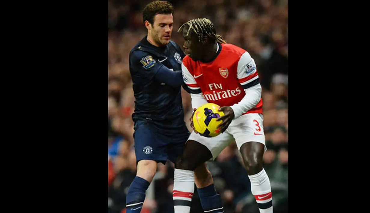 Bek asal Prancis Bacary Sagna bentrokan dengan gelandang Manchester United Juan Mata  pada pertandingan sepak bola Liga Utama Inggris antara Arsenal dan Manchester United di Stadion Emirates di London pada 12 Februari 2014.(AFP/Ben Stansall).