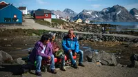 Penduduk mengobrol di Desa Kulusuk, Kota Sermersooq, Greenland, Denmark, 16 Agustus 2019. Sebagian besar penduduk Desa Kulusuk bekerja di sektor pariwisata dan perikanan lokal. (Jonathan NACKSTRAND/AFP)
