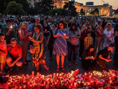 Warga menyalakan lilin untuk memperingati gadis berusia 15 tahun Alexandra yang terbunuh di depan Kementerian Dalam Negeri Rumania di Bucharest (27/7/2019). Alexandra diculik pada Rabu (24/7) ketika ia menumpang pulang ke Dobrosloveni di Rumania selatan, kata polisi.  (AFP Photo/Daniel Mihailescu)