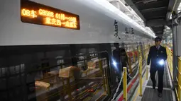 Seorang mekanik berjalan melewati kereta peluru Fuxing CR400AF di stasiun pemeliharaan depo gerbong kereta di Kota Chongqing, China (23/12/2020). Kereta ini melayani perjalanan dari Stasiun Shapingba di Chongqing menuju Stasiun Chengdu Timur di Chengdu, Provinsi Sichuan, China barat. Xinhua/Tang Yi)