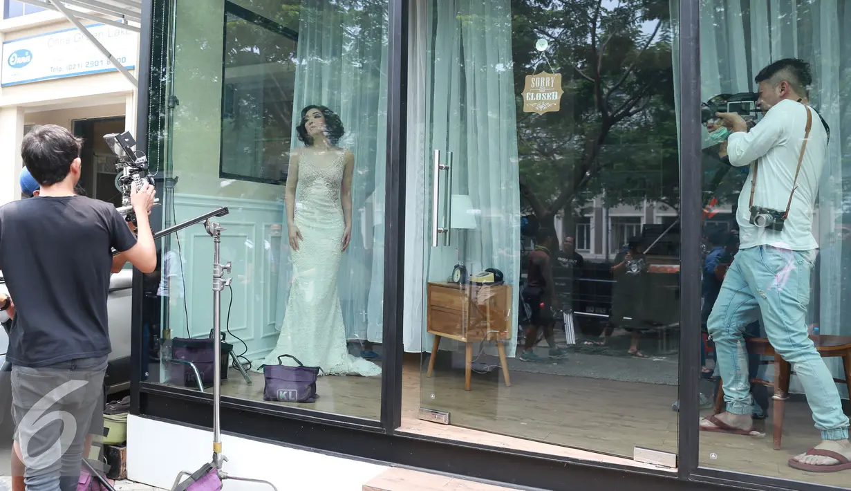 Gading Marten (kanan) ikut memotret Gisella Anastasia saat pembuatan video klip singel terbarunya, Jakarta, Selasa (18/10). Gisella Anastasia membuat video klip single terbaru "Cara Melupakanmu" dengan konsep mannequin. (Liputan6.com/Herman Zakharia)