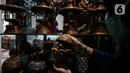 Sugito (68) menyelesaikan pembuatan miniatur Monas dari kertas koran bekas di Bank Sampah Tri Alam Lestari, Jakarta Selatan, Rabu (9/6/2021). Selain miniatur Monas, Sugito juga memanfaatkan kertas bekas untuk membuat berbagai macam barang kerajinan yang bernilai ekonomis. (Liputan6.com/Johan Tallo)