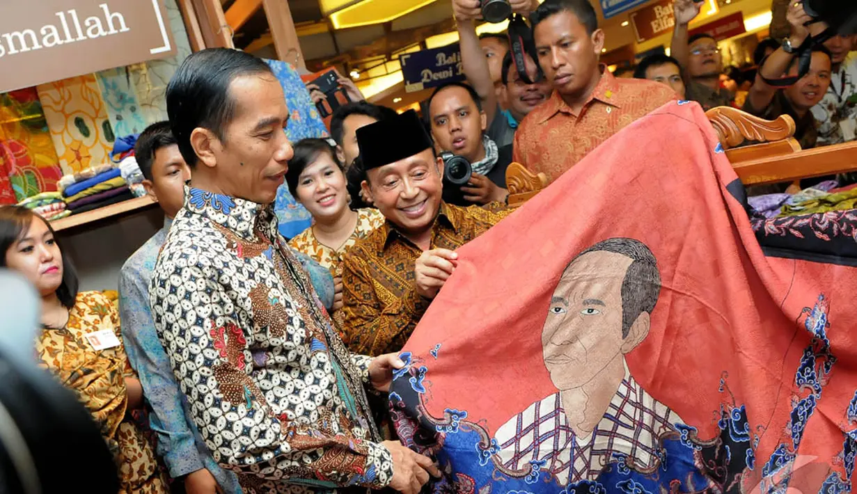 Presiden terpilih Joko Widodo melihat batik bercorak dirinya, Pasaraya Blok M, Jakarta, Kamis (2/10/2014) (Liputan6.com/Herman Zakharia)