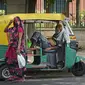 Seorang pengemudi bajaj yang kelelahan karena panas yang hebat beristirahat di dalam kendaraannya ketika seorang perempuan yang menutupi wajah berjalan melewatinya, di New Delhi, India, Kamis (19/5/2022). Meskipun hujan sporadis, ibu kota India itu masih menghadapi kondisi panas yang ekstrem. (AP Photo/Manish Swarup)