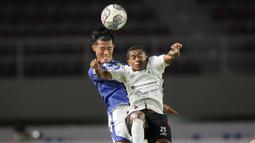 Pemain Persib Bandung, Henhen Herdiana (kiri) berduel udara dengan pemain Persipura Jayapura, Juscak Joshua Marthen Isir dalam laga pekan ke-10 BRI Liga 1 2021/2022 di Stadion Manahan, Solo, Sabtu (30/10/2021). (Bola.com/Bagaskara Lazuardi)