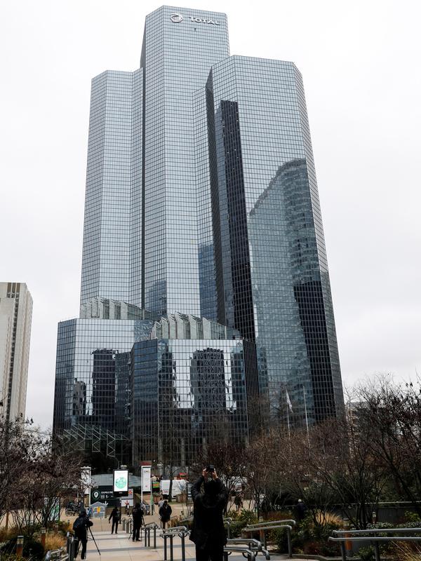 Warga menyaksikan pendaki Alain Robert atau French Spiderman memanjat Menara Total di kawasan bisnis La Defense, Paris, Prancis, Senin (13/1/2020). Alain hanya bermodalkan tangan kosong, sepasang sepatu panjat, dan sekantong kapur bubuk untuk membersihkan keringat. (Thomas SAMSON/AFP)