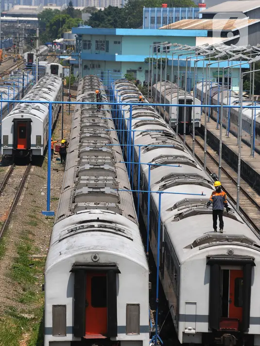 Pekerja mencuci rangkaian gerbong kereta yang terparkir di Depo Cipinang, Jakarta, Jumat (22/9/2023). Depo Cipinang menjadi tempat perawatan kereta terbesar di Indonesia dengan memiliki 28 jalur kereta. (merdeka.com/Imam Buhori)