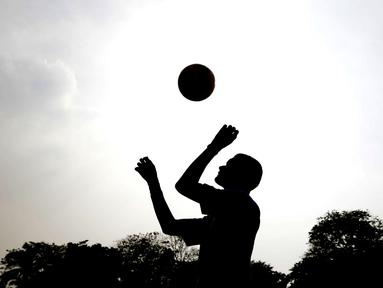 Siluet seorang anak didik menyundul bola saat mengikuti pelatihan bersama Rahmad Darwaman di Lembaga Pemasyarakatan Anak Tangerang, Banten, Senin (26/8). Latihan ini dalam rangka rencana pembuatan film. (Bola.com/Vitalis Yogi Trisna)