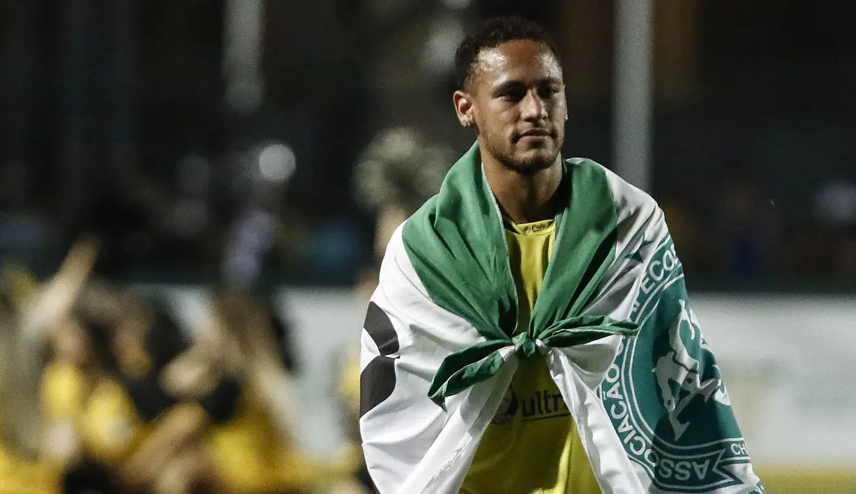 Bintang Brasil, Neymar, memakai bendera dari klub Chapecoense usai menjalani laga amal. Neymar bersama Robinho menjadi inisiator pertandingan amal yang dilakukan untuk mengenang para pemain Chapecoense. (AFP/Miguel Schincariol)