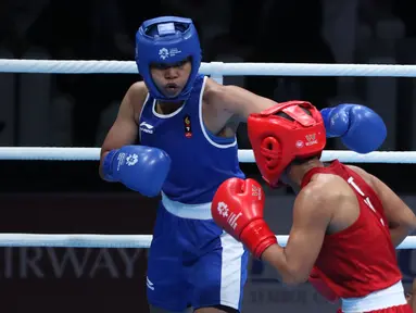 Petinju putri Indonesia, Huswatun Hasanah (kaus biru) melempaskan pukulan ke arah Sudaporn Seesondee (Thailand) pada semifinal kelas ringan 60kg putri Asian Games 2018 di JIEXPO Kemayoran, Jumat (31/8). Huswatun kalah. (Liputan6.com/Helmi Fithriansyah)