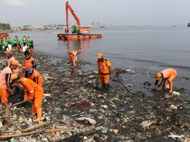 Petugas membersihkan sampah di Pesisir Teluk Jakarta, Cilincing, Jakarta Utara, Minggu (15/4). Kegiatan Gerebek Sampah ini dilakukan dalam rangka memperingati Hari Peduli Sampah Nasional (HPSN) 2018. (Liputan6.com/Arya Manggala)