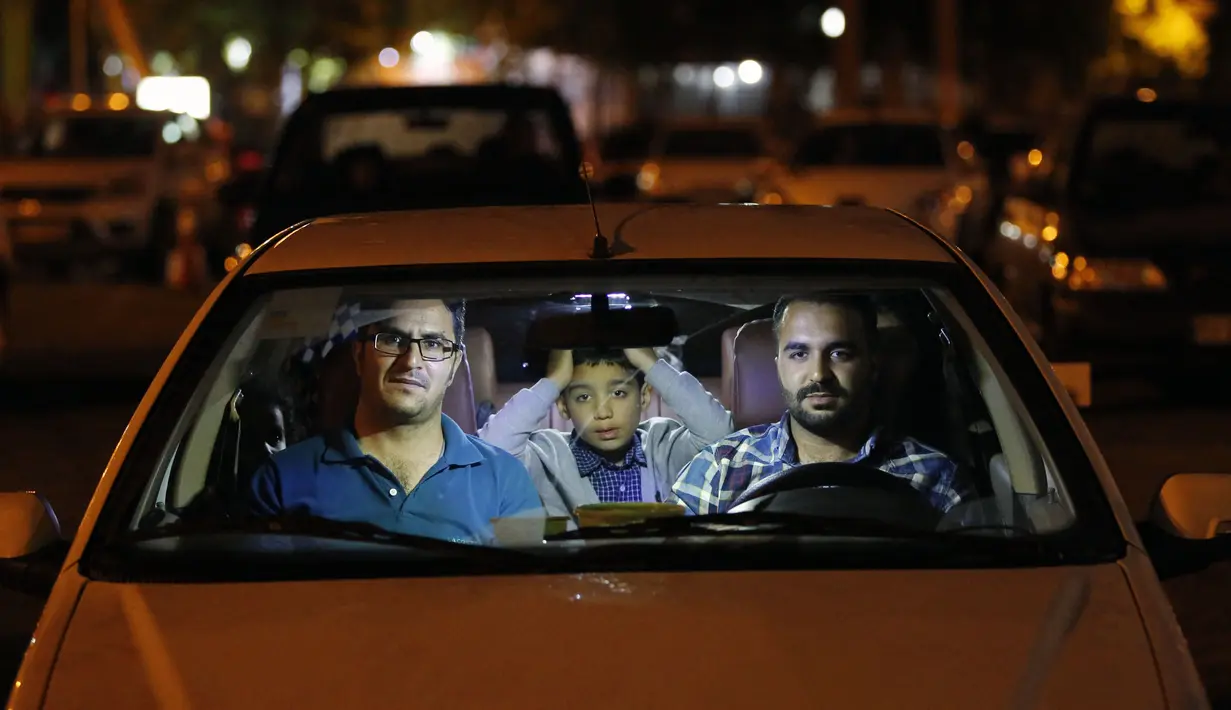 Warga duduk dalam mobil saat upacara keagamaan pada bulan suci Ramadan di tengah pandemi COVID-19, Teheran, Iran, Kamis (30/4/2020). Keluarga-keluarga di Iran menghadiri upacara keagamaan drive-in karena tidak memiliki kesempatan untuk salat di masjid setelah berbuka puasa. (STR/AFP)