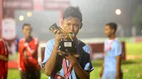 Pemain Terbaik Rusun Cup 2015 dari Rusun Daan Mogot, Mohammad Sobri, berpose dengan pialanya seusai laga final di Stadion Soemantri Brojonegoro, Jakarta, Minggu (8/11/2015). ( Bola.com/Nicklas Hanoatubun)
