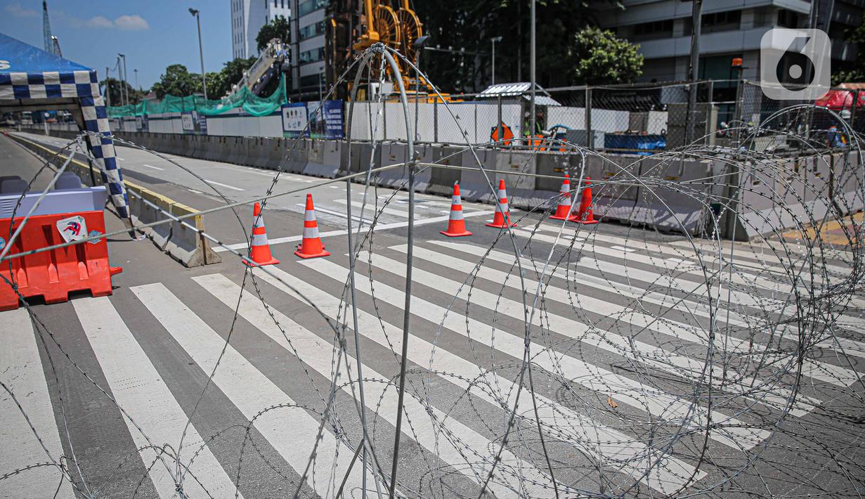 Barikade kawat berduri terpasang di kawasan Jalan MH Thamrin, Jakarta, Kamis (2/12/2021). Polda Metro Jaya memasang barikade di sejumlah titik menuju kawasan Patung Kuda-Monumen Nasional (Monas) Jakarta Pusat guna mengantisipasi kerumunan massa aksi Reuni 212. (Liputan6.com/Faizal Fanani)