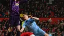 Kiper Manchester United, David de Gea menyelamatkan bola dari bek Burnley, Ben Mee dalam pertandingan pekan ke-24 kompetisi Liga Inggris 2019-2020 di Old Trafford, Rabu (23/1/2020). Manchester United (MU) tidak berdaya di kandang sendiri usai takluk 0-2 dari Burnley. (Paul ELLIS/AFP)