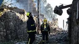 Petugas pemadan kebakaran memeriksa area yang terkena ledakan gudang kembang api di Tui, Spanyol, Rabu (23/5). Satu orang tewas dalam kejadian tersebut. (MIGUEL RIOPA/AFP)