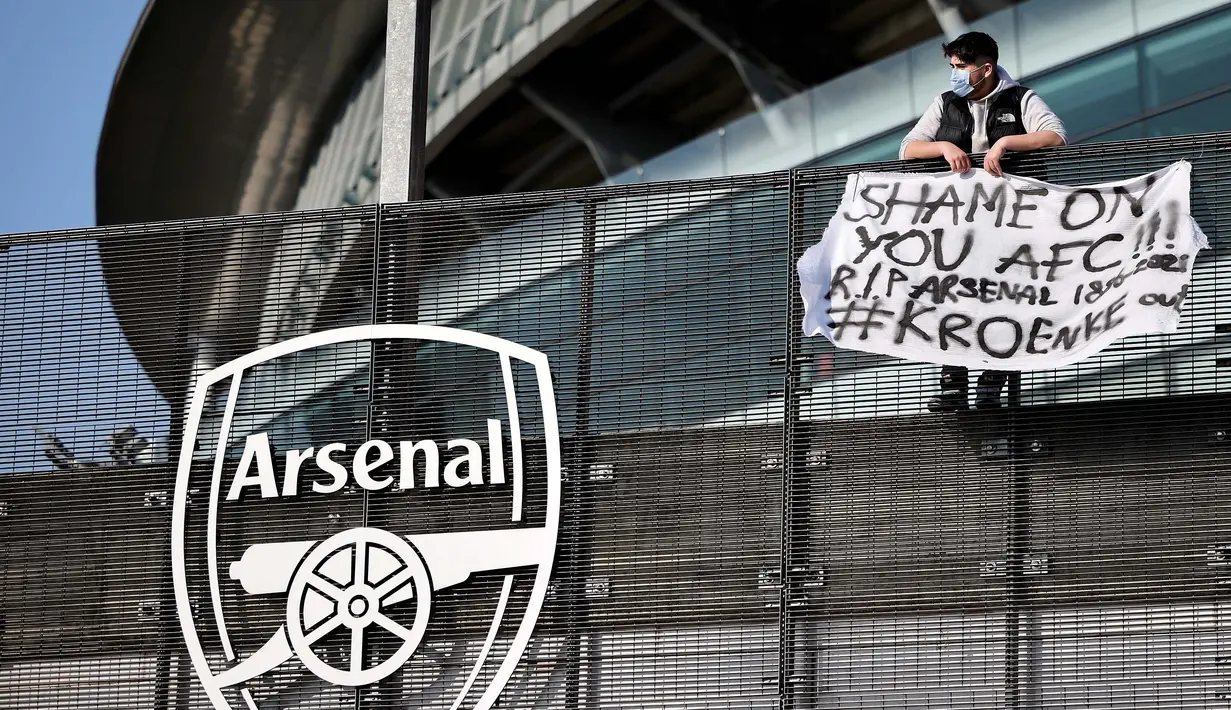 Seorang penggemar Arsenal membentangkan spanduk anti Liga Super Eropa di luar Stadion Emirates, London, Senin (19/4/2021). (Foto: AFP/Tolga Akmen)