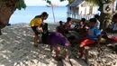 Aktivis AS, Carrie dan anak-anak membersihkan sampah plastik di bibir pantai Desa Sawandarek, Raja Ampat, Papua Barat (22/11/2019). Aksi membersihkan sampah plastik ini, digagas Carrie, aktivis asal Amerika Serikat,  yang sudah menetap di Indonesia selama 3 tahun. (Liputan6.com/Herman Zakharia)