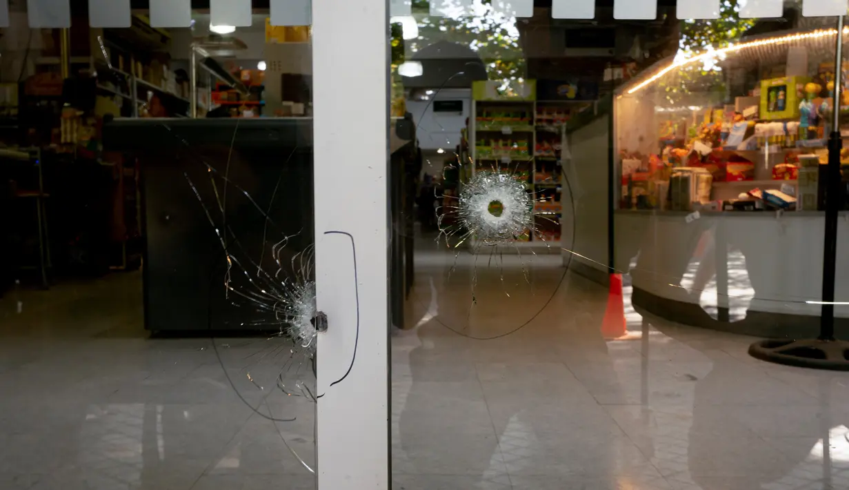 Lubang peluru memecahkan jendela supermarket Unico, jaringan toko kelontong milik mertua pemain sepak bola Lionel Messi, di Rosario, Argentina, 2 Maret 2023. Dua orang yang mengendarai sepeda motor dilaporkan menembaki toko tersebut. (AP Photo/Sebastian Lopez Brach)