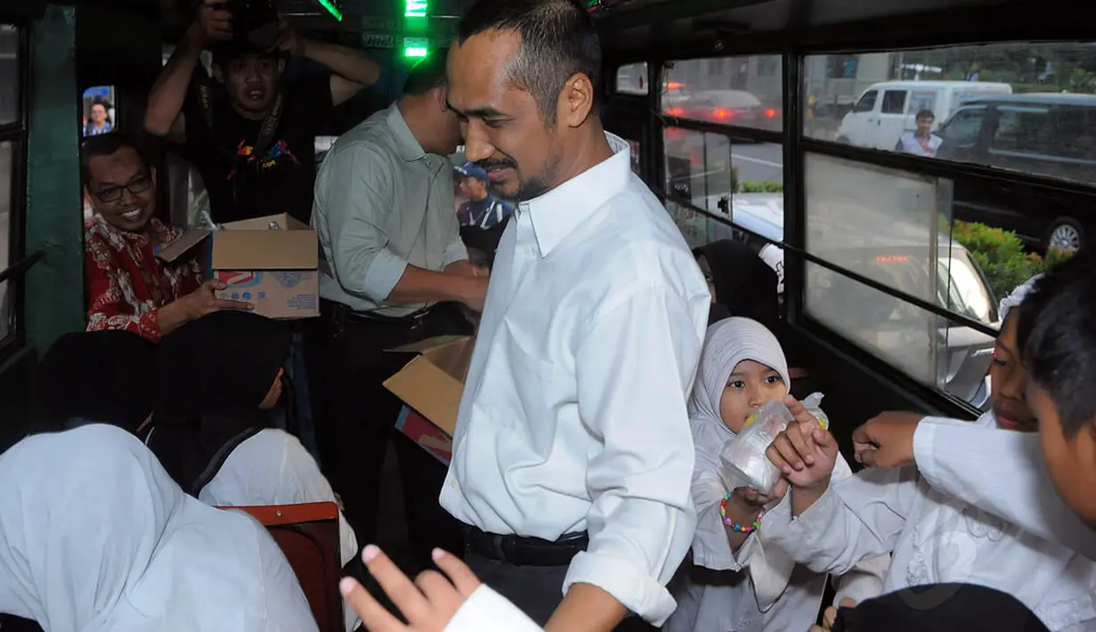 Ketua KPK Abraham Samad membagikan takjil di dalam bus Kopaja, Kamis (24/07/14). (Liputan6.com/Faisal R Syam)