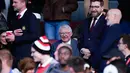 Pelatih legendaris Setan Merah, Sir Alex Ferguson, tampak tersenyum melihat Manchester United sukses melaju ke final Liga Europa 2024/2025 usai mengandaskan Athletic Bilbao dalam laga leg kedua semifinal yang dihelat di Old Trafford, Jumat (9/5/2025) dini hari WIB. (AP Photo/Dave Thompson)