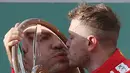 Pembalap Ferrari Sebastian Vettel dari Jerman mencium trofi setelah memenangkan balapan pertama musim ini di Grand Prix Formula Satu Australia di Melbourne, (25/3). Vattel mengungguli rival terkuatnya, Lewis Hamilton. (AP Photo / Rick Rycroft)