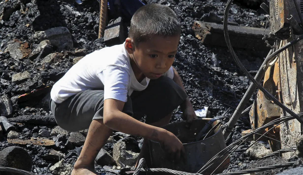 Seorang anak kecil sedang mencari barang - barangnya yang bisa dibawa pasca kebakaran yang terjadi di kota Quezon, Filipina, Jumat (23/10/2015). 325 keluarga kehilangan tempat tinggal dan sembilan orang lainnya mengalami luka-luka. (REUTERS/Romeo Ranoco)