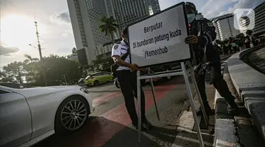 Petugas gabungan memasang plang penunjuk arah saat uji coba rekayasa lalu lintas di kawasan Bundaran HI, Jakarta Pusat, Senin sore (4/7/2022). Uji coba rekayasa lalu lintas dilaksanakan mulai hari ini, Senin 4 Juli hingga 10 Juli 2022 pukul 16.00-21.00 WIB. (Liputan6.com/Faizal Fanani)