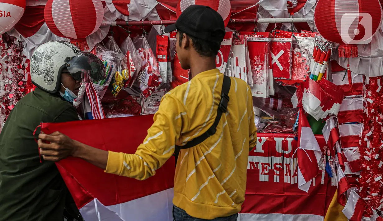 Seorang pedagang bendera merapikan umbul-umbul dan bendera yang di jual di Sepanjang Jalan Jatinegara, Jakarta, Selasa (2/8/2022). Jelang peringatan HUT Kemerdekaan RI ke-77, pedagang musiman bendera  mulai bermunculan mereka memanfaatkan trotoar untuk memajang dagangannya, mulai dari umbul-umbul, bendera, hingga ornamen khas merah putih lainnya dengan harga yang tawarkan juga bervariasi, mulai dari Rp. 5.000 ,- hingga Rp. 300.000,. (Liputan6.com/Faizal Fanani)