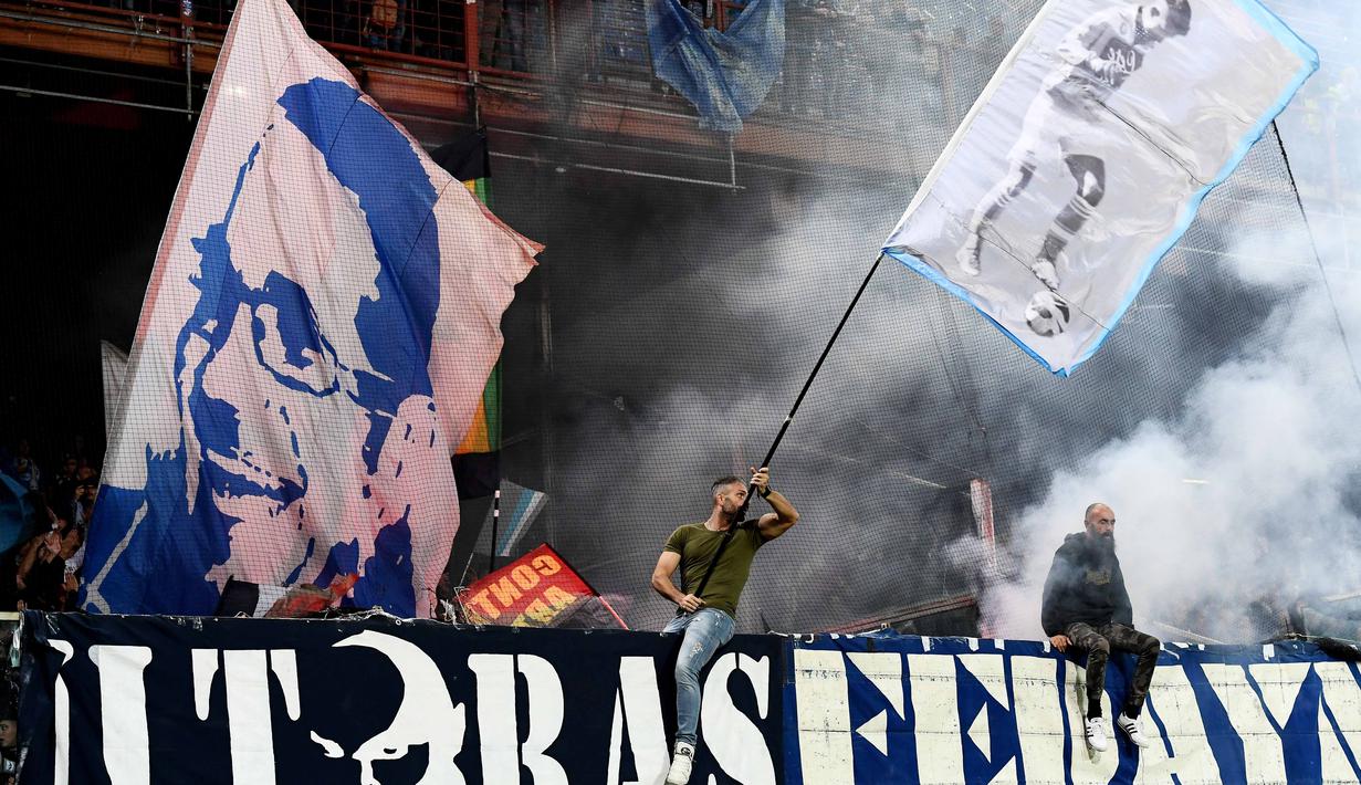 Aksi fans Napoli mengibarkan bendera saat mendukung timnya melawan Genoa pada lanjutan Serie A di Luigi Ferraris stadium, Genoa, (25/10/2017). Napoli menang 3–2. (AFP/Vincenzo Pinto)