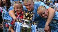 Striker Man City Erling Haaland dengan trofi juara Liga Inggris musim ini. (OLI SCARFF / AFP)