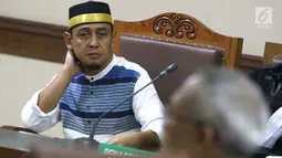 Terdakwa penyebaran berita bohong tentang 7 kontainer berisi surat suara Pemilu 2019 yang telah tercoblos, Bagus Bawana Putra menyimak keterangan Kepala Biro Hukum Sekjen KPU, Sigit Joyowardono saat sidang lanjutan di Pengadilan Negeri Jakarta Pusat, Kamis (11/4). (Liputan6.com/Helmi Fithriansyah)