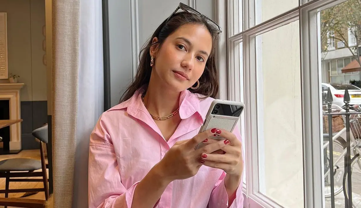 Pevita Pearce terlihat begitu santai dengan memakai kemeja pink serta anting dan kalung model sederhana. Dirinya juga menambahkan sebuah kacamata untuk penampilan kasualnya. (Liputan6.com/IG/@pevpearce)