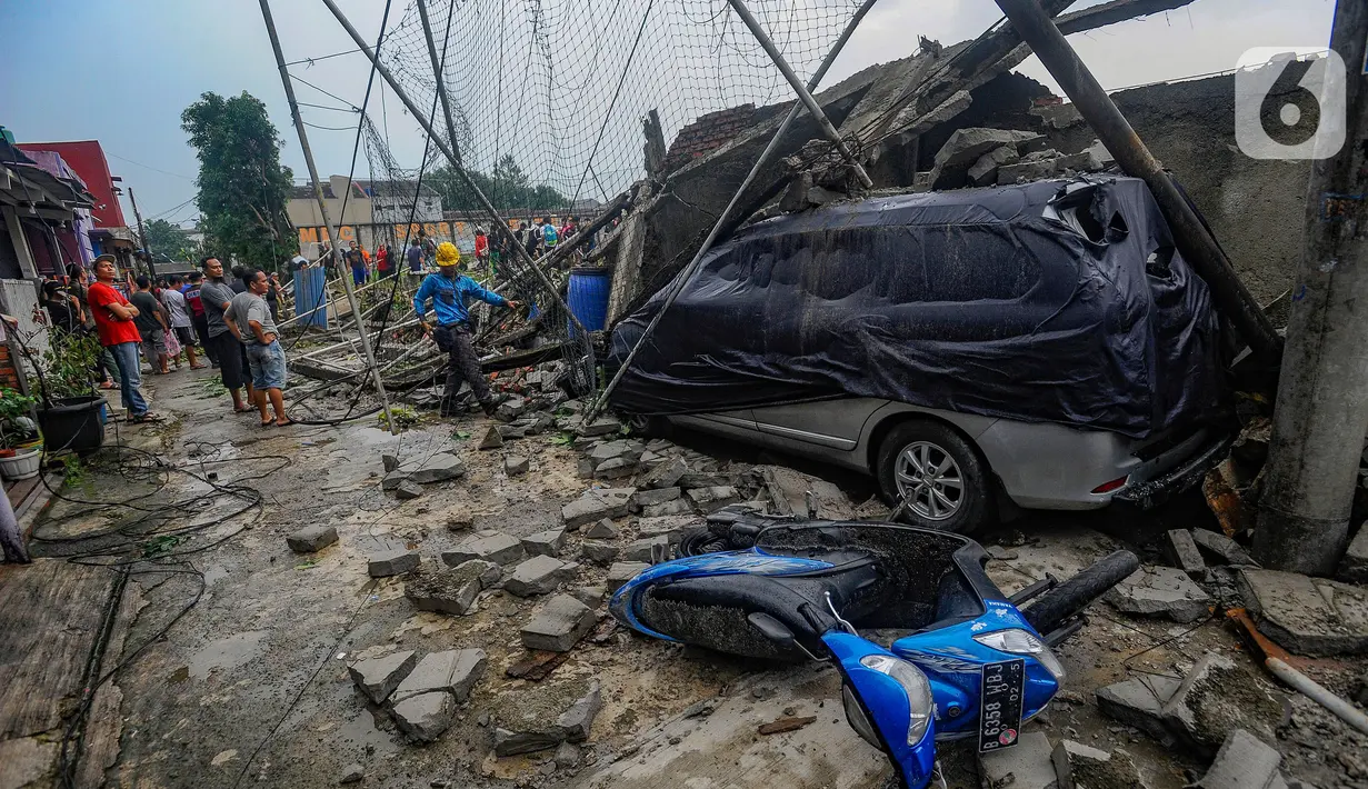 Warga menyaksikan bangunan tembok lapangan Sekolah Amec yang roboh di Pamulang Elok, Tangerang selatan, Banten, Jumat (8/12/2023). (merdeka.com/Arie Basuki)