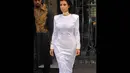 Kim Kardashian tampil cantik mengenakan gaun warna putih silver berpotongan lengan panjang dan ketat di tubuh, Paris, (25/9/14). (Dailymail)