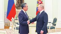 Kepala Kebijakan Luar Negeri Partai Komunis China sekaligus diplomat paling senior negara itu, Wang Yi, saat bertemu dengan Presiden Rusia Vladimir Putin di Kremlin, Moskow, pada Rabu (22/2/2023). (Dok. AFP)