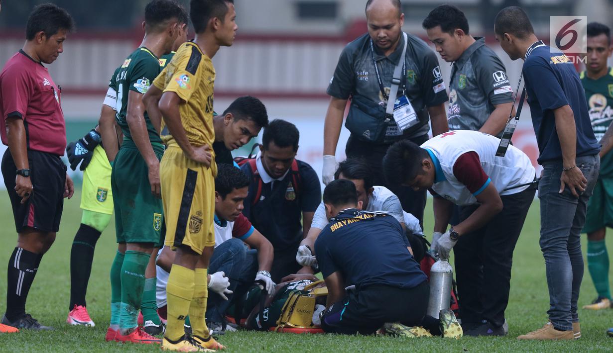 Petugas medis memberi pertolongan kepada pemain Persebaya, Andri Muladi saat laga melawan Bhayangkara FC pada lanjutan Go-Jek Liga 1 Indonesia bersama Bukalapak di Lapangan PTIK, Jakarta, Rabu (11/7). Laga berakhir imbang. (Liputan6.com/Helmi Fthriansyah)