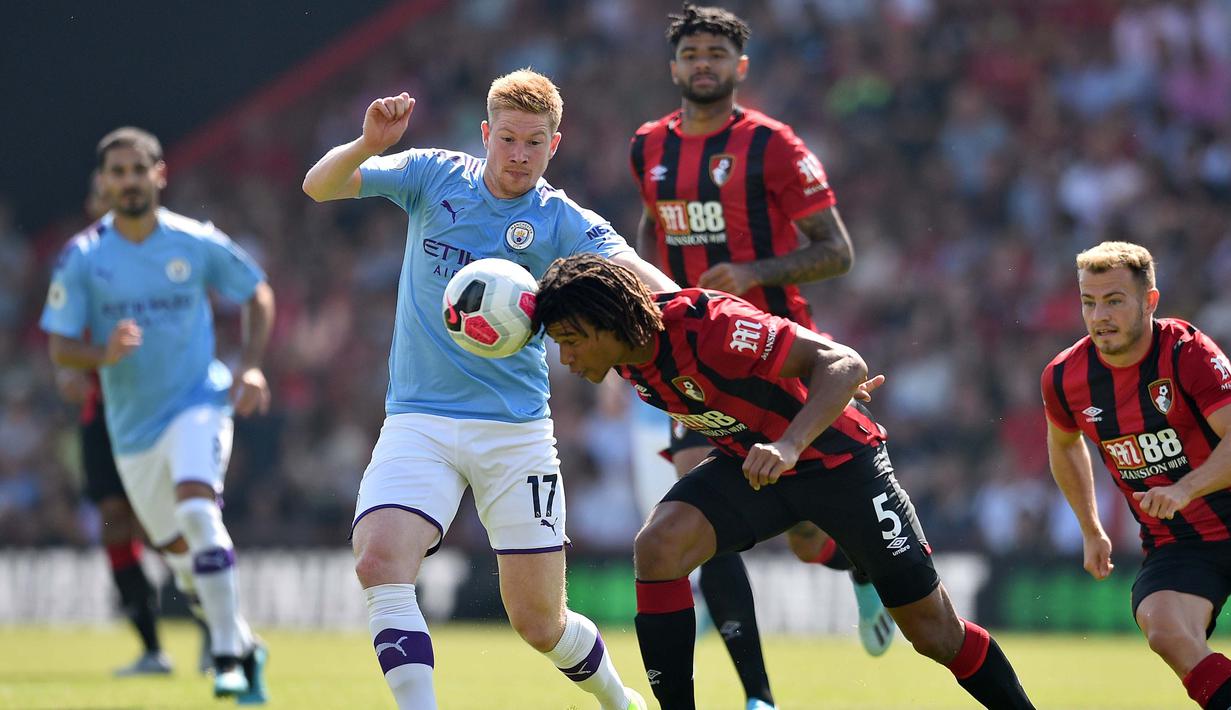 Gelandang Manchester City, Kevin De Bruyne, berebut bola dengan bek Bournemouth, Nathan Ake, pada laga Premier League 2019 di Stadion Vitality, Minggu (25/8). Manchester City menang 3-1 atas Bournemouth. (AFP/Glyn Kirk)