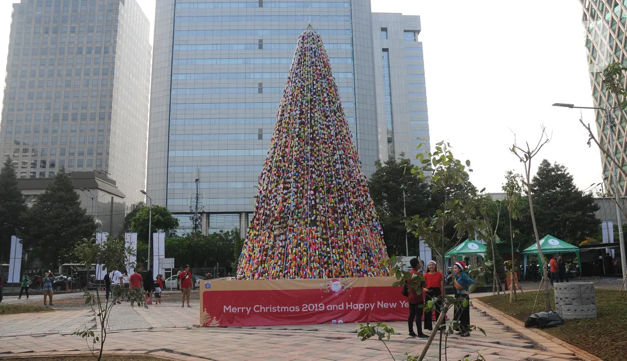 Warga melihat pohon Natal dari miniatur ondel-ondel yang terbuat dari botol minuman bekas di Food Court Thamrin 10, Jakarta, Sabtu (21/12/2019). Sekitar 8.000 botol air mineral bekas dihias dan dirangkai menyerupai Pohon Natal yang bisa disaksikan oleh masyarakat. (Liputan6.com/Helmi Fithriansyah)