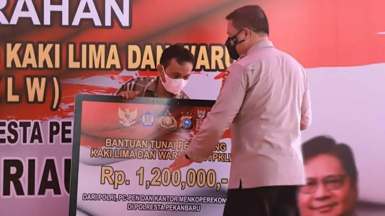 Kapolda Riau Irjen Agung Setya Imam Effendi menyerahkan bantuan dari pemerintah untuk pedagang kaki lima.